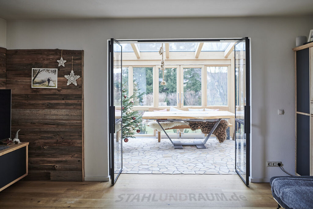 Metall Falttür voll geöffnet als Trennwand zu Wintergarten