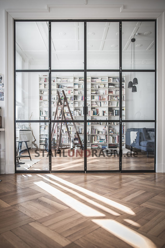 Metall Raumteiler in einer luxuriösen Berliner Loft. Sonnenlicht und Holzfußboden spielen mit der Trennwand.