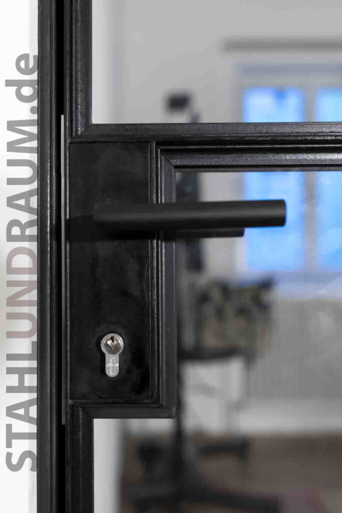 Schlosskasten mit Türklinke an Stahl-Glas-Raumteiler. Oberfläche Stahl natur geölt.