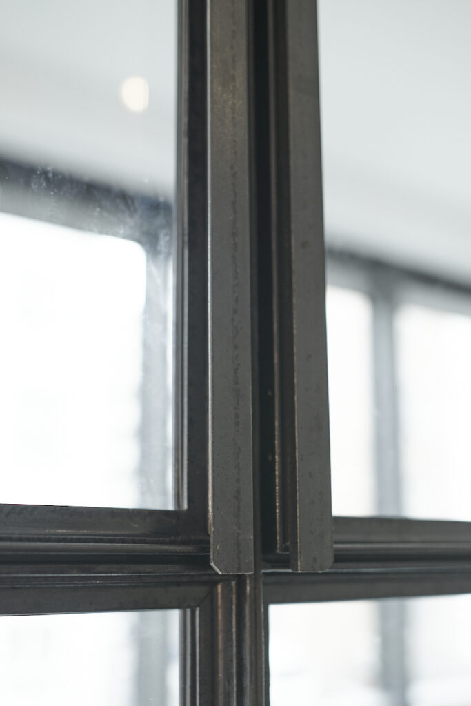 Griffe aus Winkelstahl an Bauhaus Fenster aus Stahl und Glas.